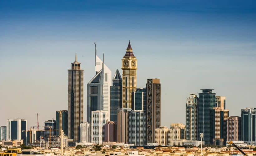 Panoramic view of Dubai's modern skyline featuring iconic skyscrapers in the financial district under a clear sky.