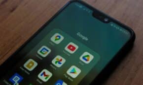 Close-up of a smartphone showing various Google apps on its screen.