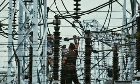 Electricians working on power lines, ensuring grid maintenance and safety.