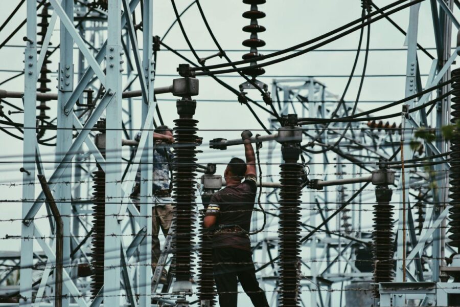Electricians working on power lines, ensuring grid maintenance and safety.