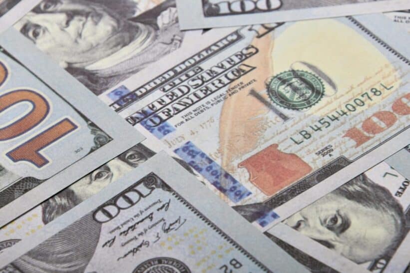 Detailed close-up of multiple US dollar banknotes showing currency details and design.
