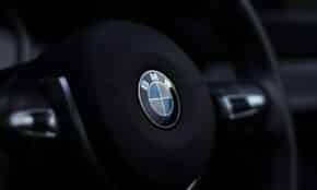 Detailed view of a BMW steering wheel emblem with a stylish depth of field effect.