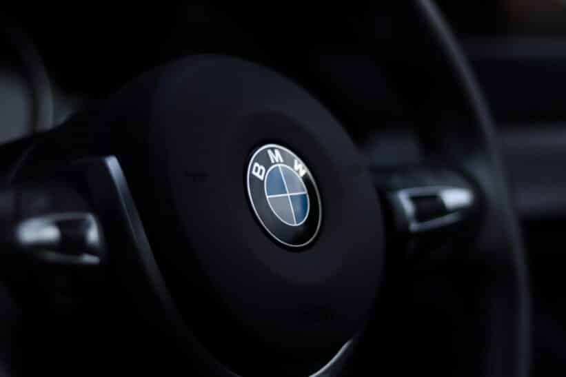 Detailed view of a BMW steering wheel emblem with a stylish depth of field effect.