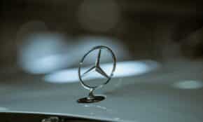 Close-up of a Mercedes-Benz emblem on a car hood, highlighting luxury and elegance.