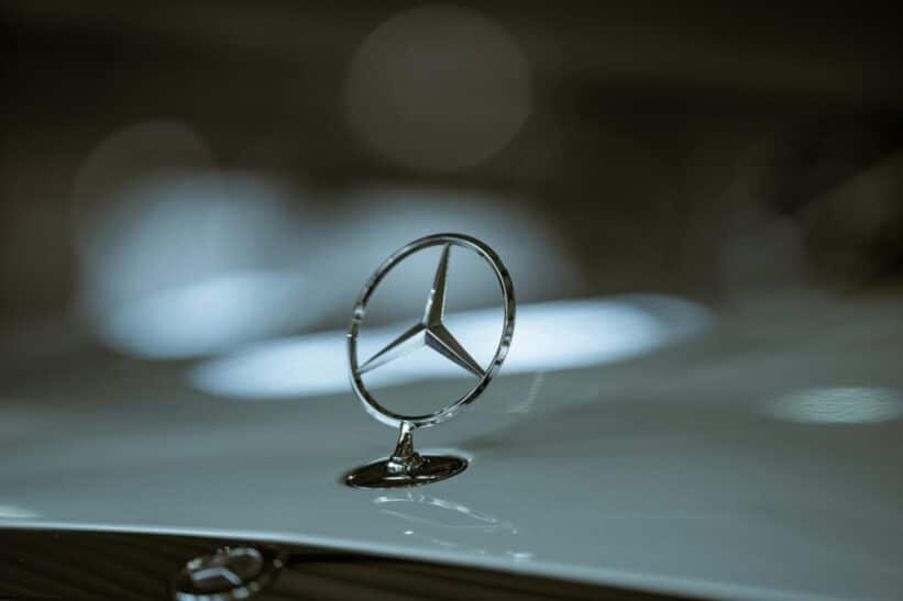 Close-up of a Mercedes-Benz emblem on a car hood, highlighting luxury and elegance.