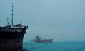 Cargo ships navigate a foggy ocean, highlighting global logistics and transportation.