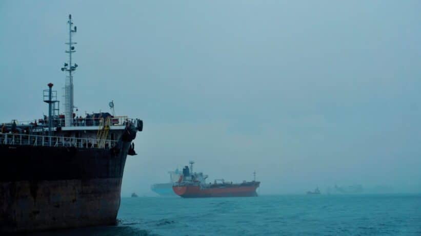 Cargo ships navigate a foggy ocean, highlighting global logistics and transportation.