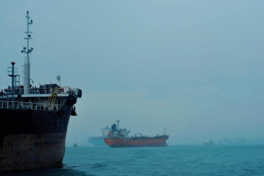 Cargo ships navigate a foggy ocean, highlighting global logistics and transportation.
