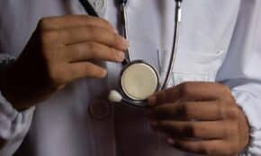 A close-up image showing a doctor holding a stethoscope, symbolizing healthcare and medical practice.