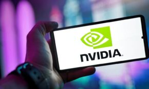 Close-up of a hand holding a smartphone showing the NVIDIA logo on screen with a blurred background.