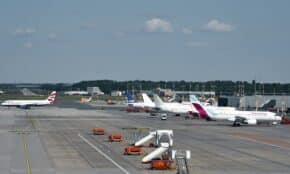 Airplanes on the runway at Hamburg Airport on a clear day, showcasing bustling air travel.