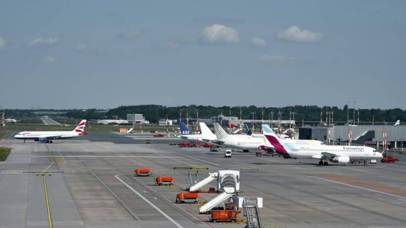 Airplanes on the runway at Hamburg Airport on a clear day, showcasing bustling air travel.