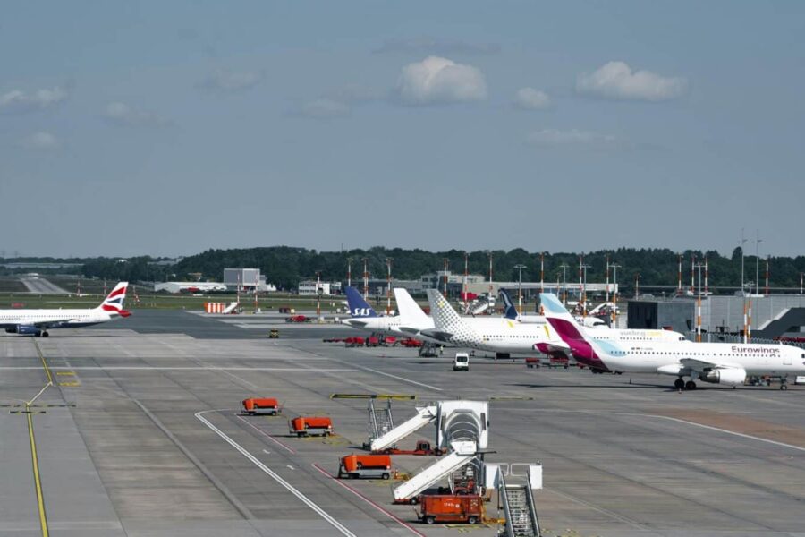 Airplanes on the runway at Hamburg Airport on a clear day, showcasing bustling air travel.