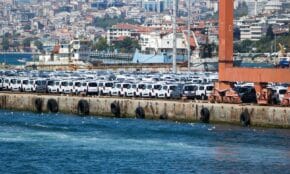 A large shipment of white cars at a bustling port in İstanbul, Türkiye.