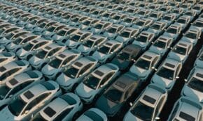 Overhead view of neatly arranged cars in a Libyan parking lot, captured at day.