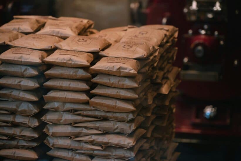 Stacked brown paper packages in an industrial warehouse setting. Perfect for logistics visuals.
