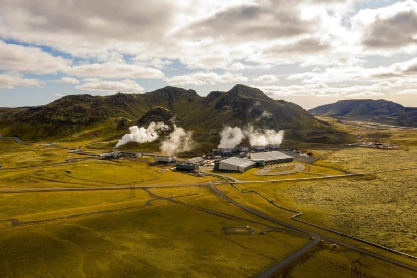 Aerial view of Hellisheidi geothermal power plant with mountains and steam in Iceland