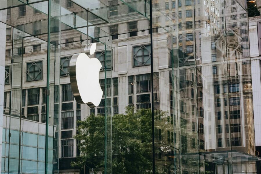 Transparent walls of modern company building with label icon against old building in downtown