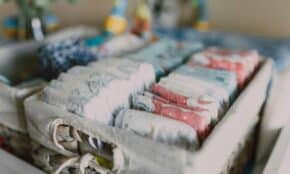 Close-up of neatly arranged colorful baby diapers in a woven basket, ideal for nursery organization.