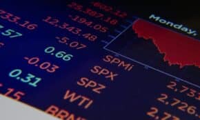 Close-up of a digital stock market graph showing falling trends and financial indices in red and green.