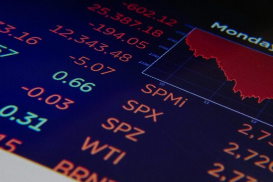 Close-up of a digital stock market graph showing falling trends and financial indices in red and green.