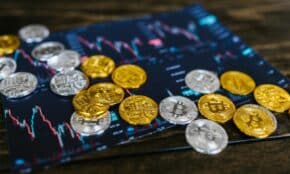 Gold and silver Bitcoin coins on financial graph, symbolizing cryptocurrency trading and digital currency wealth.
