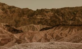 Astronauts exploring a stunning desert landscape, resembling Mars.