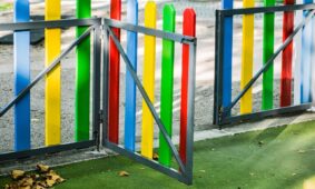 play area, playground, fence, colourful, golden light, sunny, kids, nature, fun, children, play, school yards, school yard fence, kindergarten fence, kindergarten play yard, outsider, leaves, autumn, dried leaves, park gate