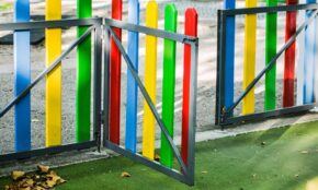 play area, playground, fence, colourful, golden light, sunny, kids, nature, fun, children, play, school yards, school yard fence, kindergarten fence, kindergarten play yard, outsider, leaves, autumn, dried leaves, park gate