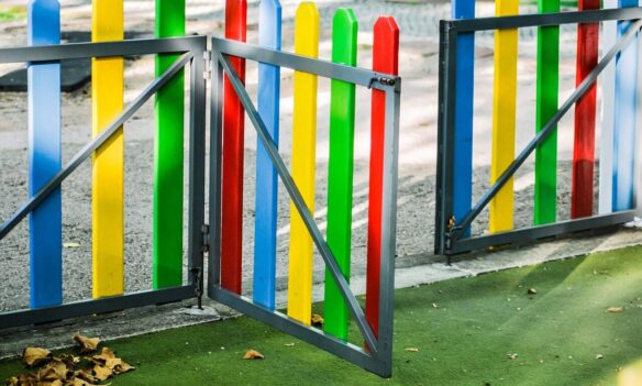 play area, playground, fence, colourful, golden light, sunny, kids, nature, fun, children, play, school yards, school yard fence, kindergarten fence, kindergarten play yard, outsider, leaves, autumn, dried leaves, park gate