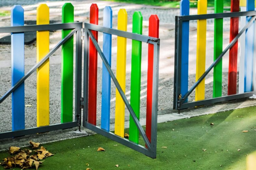 play area, playground, fence, colourful, golden light, sunny, kids, nature, fun, children, play, school yards, school yard fence, kindergarten fence, kindergarten play yard, outsider, leaves, autumn, dried leaves, park gate