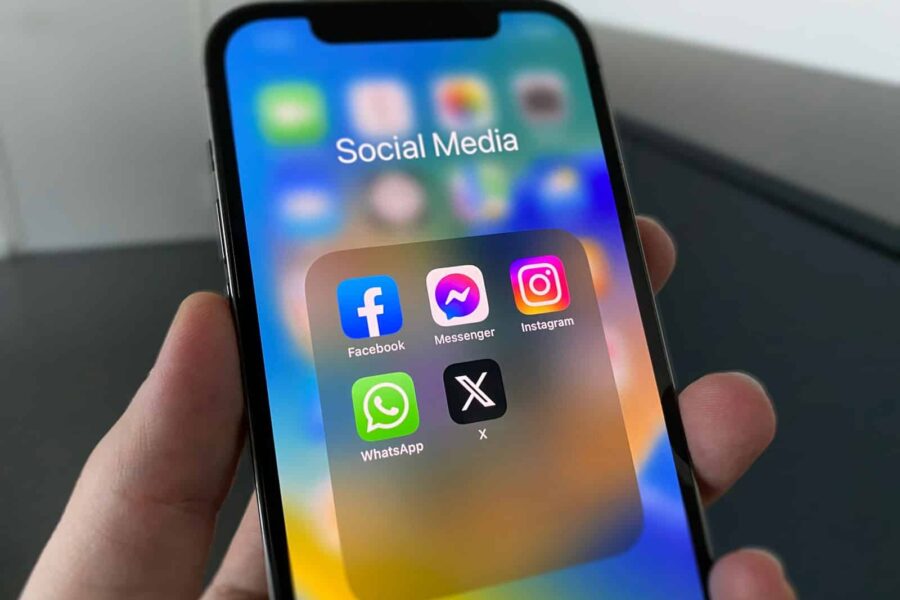 a person holding a cell phone with social media on the screen
