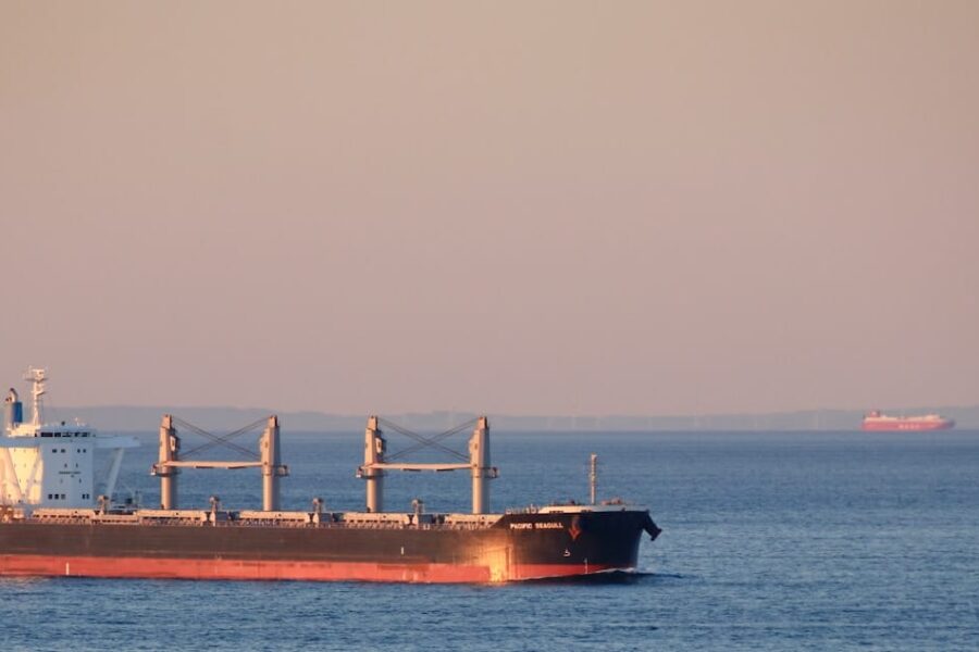 red ship on sea under gray sky during daytime