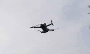 A drone flies in the cloudy sky