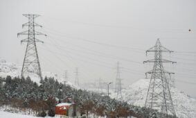 a snow covered mountain with power lines in the background
