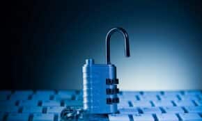 An unlocked padlock rests on a computer keyboard.