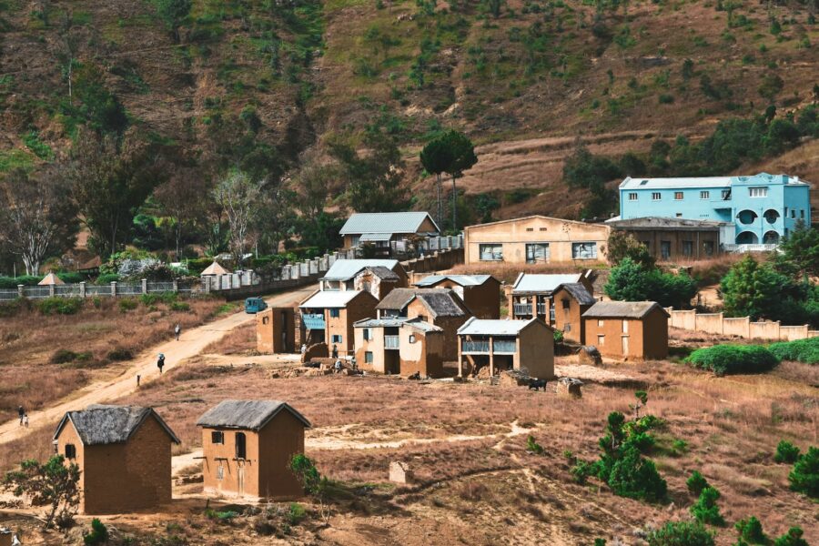 brown and white concrete houses near green trees during daytime
