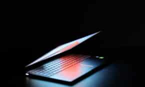 black and gray laptop computer turned on in dark room