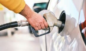 a man pumping gas into his car at a gas station