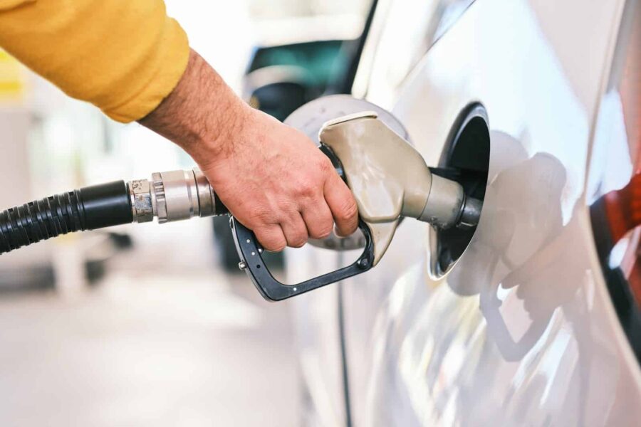 a man pumping gas into his car at a gas station