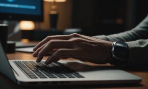 Person's hand hovering over computer mouse with laptop screen glowing, depicting digital privacy decision-making